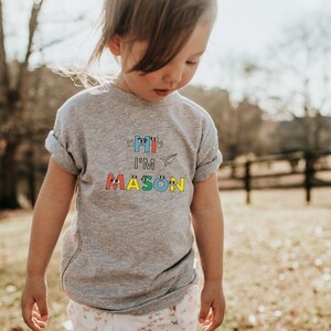Caras de letras felizes personalizadas para crianças pequenas, camiseta de manga curta, nome personalizado, mãos acenando, avião de papel, design único, roupas infantis exclusivas