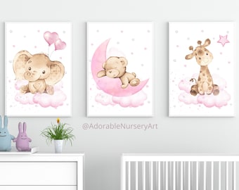 May include: Three framed wall art prints featuring watercolour illustrations of a baby elephant with pink heart balloons, a teddy bear sleeping on a pink crescent moon, and a giraffe sitting on a pink cloud, all accented with small pink stars.