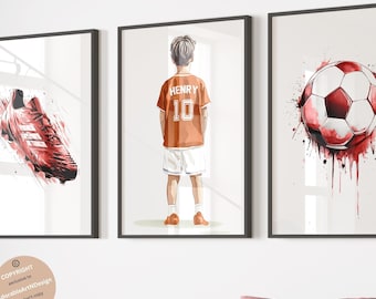 Puede incluir: Un conjunto de tres láminas de pared enmarcadas que muestran una bota de fútbol roja con efectos de salpicaduras de pintura, un niño visto desde atrás con una camiseta naranja con el nombre HENRY y el número 10, y un balón de fútbol rojo y blanco.