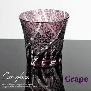 Puede incluir: Un vaso de cristal tallado de color uva con un diseño geométrico. El vaso es versátil, adecuado para el uso diario o para sake. El texto "Cut glass" y "Grape" son visibles.