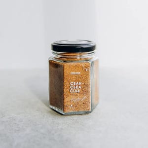 May include: A glass jar with a black lid filled with brown spice blend. The label reads "Svan-ska Sial" and "Taste it".