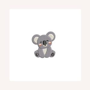 May include: Embroidered gray koala bear with a smiling face and rosy cheeks. The koala has large, round ears with cream-colored inner details and is sitting down. The design is on a white background.