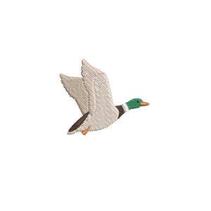May include: An embroidered patch featuring a mallard duck in flight. The duck has a green head, a white neck ring, a brown chest, and light tan wings with dark brown accents. The beak is orange and the small feet are also orange.