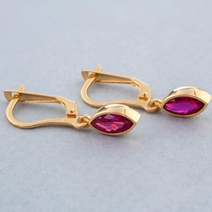 Peut inclure: Une paire de boucles d'oreilles en or avec une pierre précieuse rose en forme de marquise qui pend de chaque boucle d'oreille.