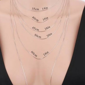 Op de afbeelding: Een zilveren kettingketting in verschillende lengtes, vari&euml;rend van 14 inch tot 32 inch. De ketting wordt getoond op de nek van een model, met de lengtes aangegeven in zowel inch als centimeters.
