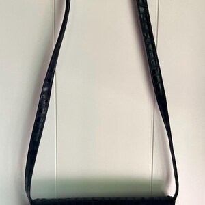 May include: A black crocodile-embossed leather shoulder bag with a gold clasp.