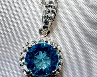 Sterling Silber Halo Anhänger Halskette mit einem Runden Blautopas, umgeben von Pave Kristallen.