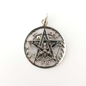 Puede incluir: Pendiente de plata con un pentagrama rodeado de un círculo. El círculo tiene las palabras "The True Will" inscritas alrededor del pentagrama.