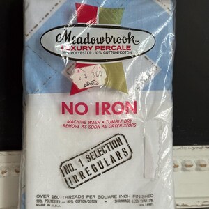 May include: Sealed package of Meadowbrook luxury percale pillowcases. The package features a blue and white argyle pattern. The label reads "No Iron" and "Two Pillowcases 42 x 36". The package also has a "No. 1 Selection Irregulars" stamp.