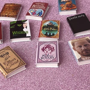 Puede incluir: Una colección de portadas de libros en miniatura con varios títulos, incluyendo "Wicked", "Oliver Twist", "Madame Bovary", "Harry Potter", "ALF", "Death Note", "Recently Deceased" y "Prince Harry Spare".