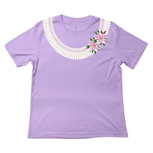 May include: A light purple short-sleeve t-shirt featuring a white graphic print of a decorative lace-style collar around the neckline. Two pink flowers with green leaves are positioned on the right side of the collar graphic on the chest area.