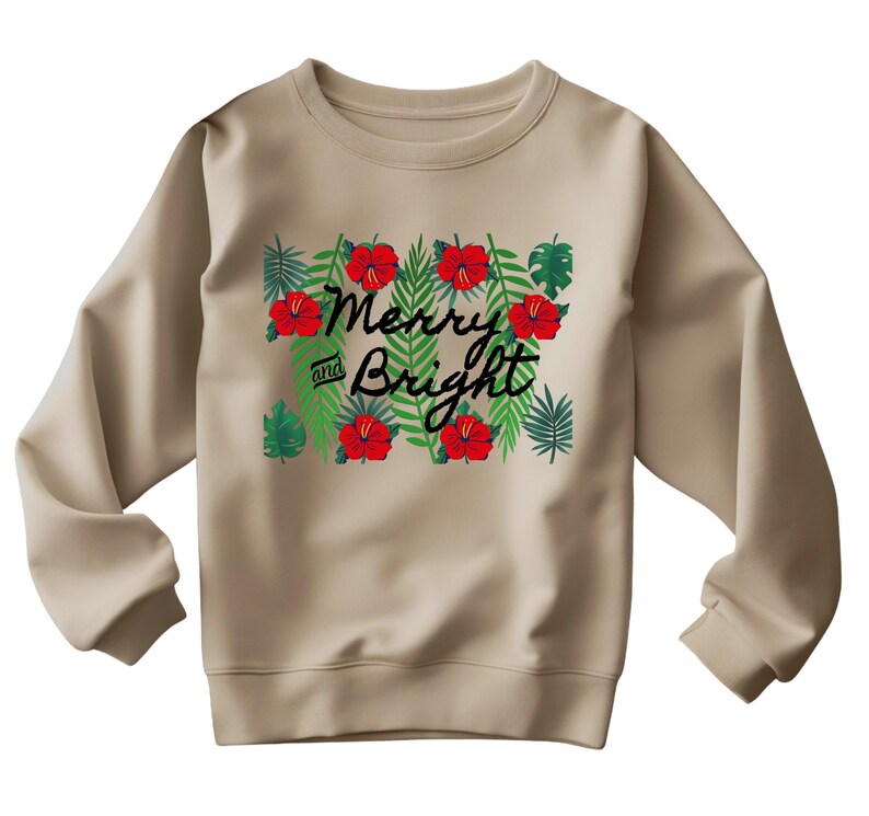 May include: A tan sweatshirt with a festive design. The graphic features the words "Merry and Bright" in black script, surrounded by red hibiscus flowers and green tropical leaves. The sweatshirt has long sleeves and a crew neck.