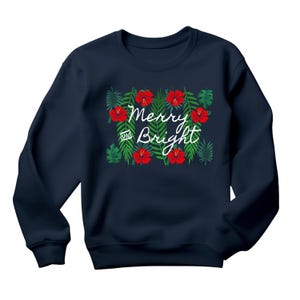 May include: Navy blue sweatshirt with a festive design. The design features red hibiscus flowers and green leaves, with the words "Merry and Bright" in white script. A cozy and stylish holiday apparel item.