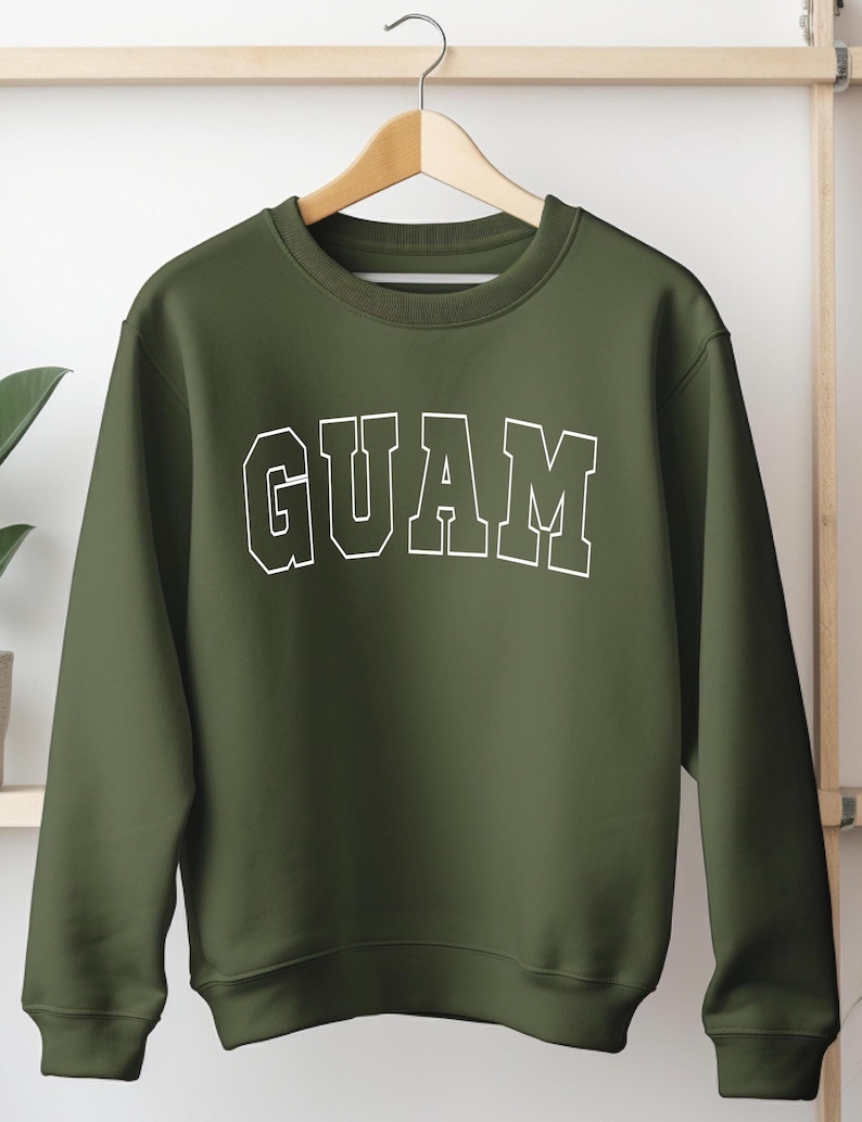 Op de afbeelding: Een groen sweatshirt met het woord "GUAM" in wit op de voorkant.
