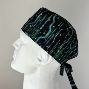 May include: A black scrub cap with a green and blue circuit board pattern. The cap has a tie at the back.