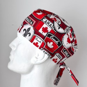May include: A red and white surgical scrub hat with a Canadian theme. The hat features a variety of Canadian symbols, including the Canadian flag, maple leaves, and the words "Canada" and "Coast to Coast".