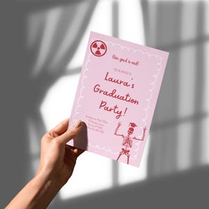 Könnte beinhalten: Rosafarbene Einladung zur Abschlussfeier mit rotem Text, darunter "Laura's Graduation Party!". Das Design umfasst eine Skelettillustration und ein Strahlungssymbol. Oben auf der Einladung steht "this grad is rad!"