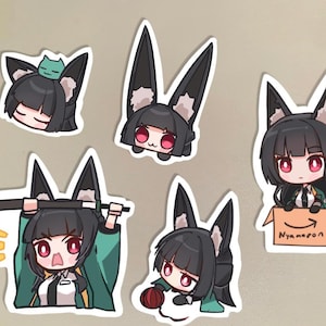 May include: Five black and green anime character stickers with different expressions. The stickers are on a light brown surface. One sticker shows the character holding a sword, another is in a box labeled "Nyampon", and another is holding a ball of yarn.