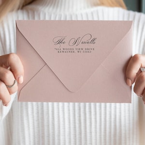 May include: A pink envelope with a return address label that reads "The Newells, 7614 Woods View Drive, Kewaunee, WI 53063"