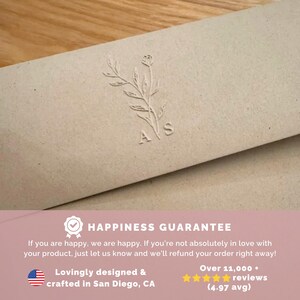 May include: Close-up of a beige paper product with an embossed floral design and the letters "A S". The product has a Happiness Guarantee and is lovingly designed and crafted in San Diego, CA.