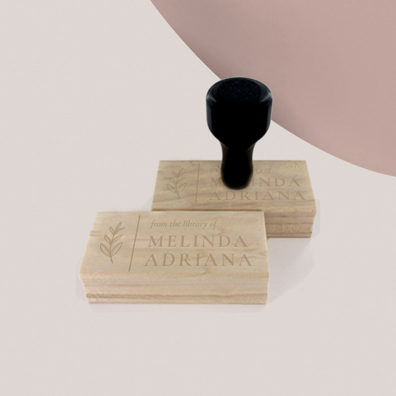May include: Two wooden stamps with a leafy design and the text "from the library of Melinda Adriana". The top stamp has the text "from the library of Melinda Adriana".