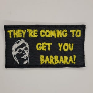 May include: Black embroidered patch with yellow text that reads "They're coming to get you Barbara!" and a white embroidered image of a man wearing glasses.