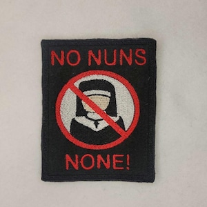 May include: Black embroidered patch with a red circle and a diagonal red line through it. The circle contains a white outline of a nun with a black habit. The text "NO NUNS NONE!" is embroidered in red on the patch.