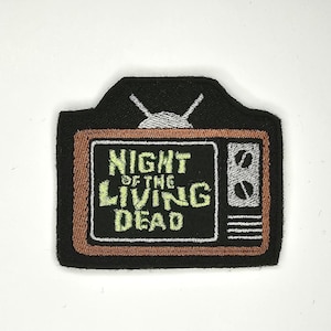 以下が含まれることがあります： レトロなテレビに「ナイト・オブ・ザ・リビング・デッド」という文字が緑と白で書かれた、黒と茶色の刺繍パッチです。