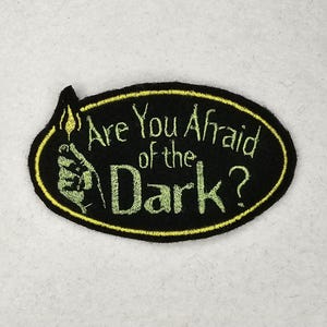 May include: Black and yellow embroidered patch with the text "Are You Afraid of the Dark?"