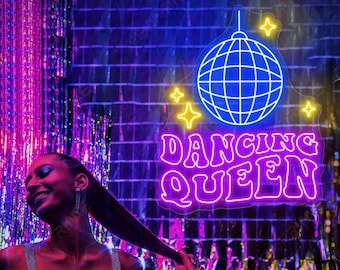 Może przedstawiać: Neonowy znak z dyskotekową kulą i napisem "Dancing Queen" w kolorze różowym. Znak jest podświetlony i ma fioletowy blask. Kobieta stoi przed znakiem, uśmiecha się i trzyma kieliszek szampana.