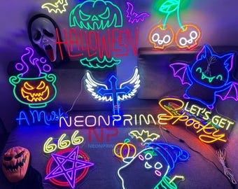 Op de afbeelding: Een verzameling neonborden met Halloween-thema's, waaronder een pompoen, een vleermuis, een spook, een ketel, een pentagram, een kruis met vleugels en de tekst "Happy Halloween", "Let's Get Spooky" en "666".