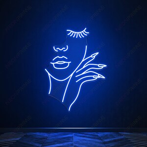 May include: A neon sign depicting a stylised outline of a woman's face with closed eyes and a hand resting on her chin. The sign is lit in a bright blue colour.