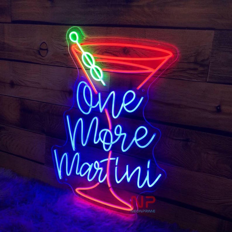 Pu&ograve; includere: Insegna al neon a forma di bicchiere da Martini con le parole "One More Martini" in neon blu. Il contorno del bicchiere da Martini &egrave; rosso, con un'oliva verde e uno stelo. Su sfondo di legno.