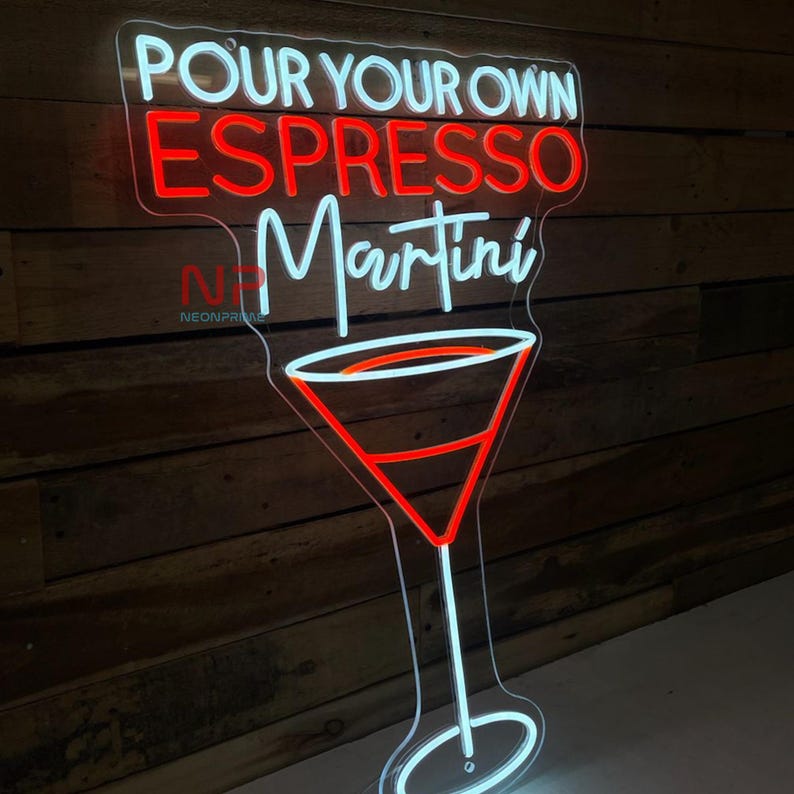 Pu&ograve; includere: Un'insegna al neon a forma di bicchiere da Martini con le parole "POUR YOUR OWN ESPRESSO MARTINI" in bianco e rosso. L'insegna &egrave; montata su una parete di legno.