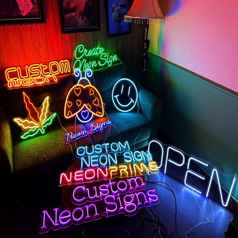 May include: A collection of neon signs in a variety of colours and designs, including "Custom Neon", "Create Neon Sign", "Neon Signs", "Custom Neon Sign", "Neon Prime", "Custom Neon Signs", "Open", a ladybug, a marijuana leaf, and a smiley face.