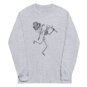 May include: A light grey long-sleeve shirt featuring a black illustration of a running skeleton carrying an axe and a turkey. The design is a humorous take on a classic theme.