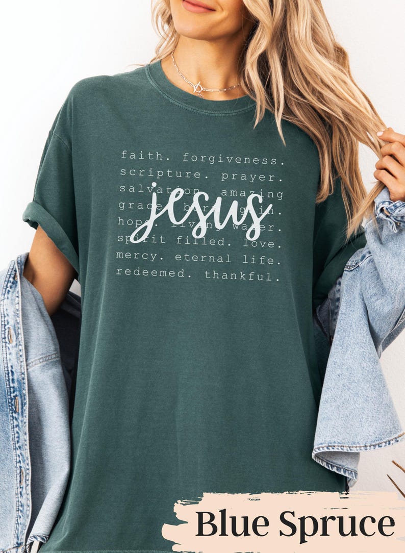 May include: Blue Spruce colored t-shirt with the word "Jesus" in a cursive font. The shirt features a list of words including "faith", "forgiveness", and "love". The shirt is a comfortable, casual style.