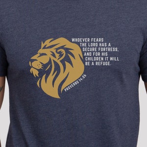 May include: A navy blue t-shirt with a gold lion graphic and the text "Whoever fears the Lord has a secure fortress. And for his children it will be a refuge. Proverbs 14:26"