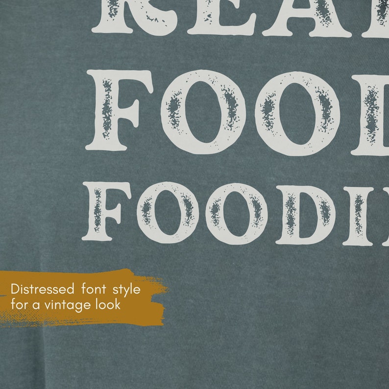 May include: A blue t-shirt with white text that reads "Real Food Foodie" in a distressed font style.