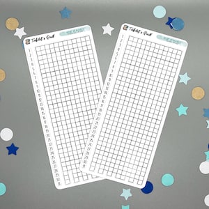 May include: Two white rectangular stickers with a grid pattern and the text "Tablets & Quill" and "Year of Goals". The stickers are surrounded by blue, white, and gold confetti in star and circle shapes.