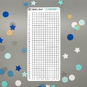 May include: A white rectangular sticker with a grid for tracking daily habits, surrounded by blue, teal, and gold star and circle confetti. The sticker has the text "Tablet & Quill" and "year in pixels".
