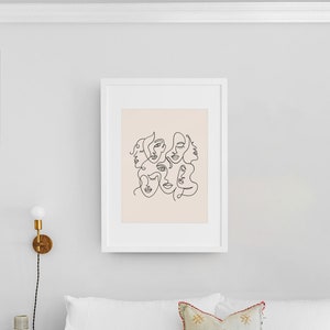 May include: A framed print featuring a minimalist line drawing of several faces in black against a cream background.