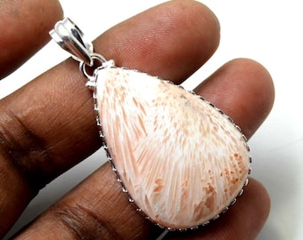 Op de afbeelding: Een traanvormige hanger met een witte en roze gefossiliseerde koraalsteen, gezet in een zilveren bezel. De hanger heeft een zilveren bail om aan een ketting te bevestigen.