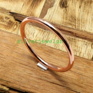 May include: A simple rose gold bangle bracelet. The bracelet is smooth and shiny.