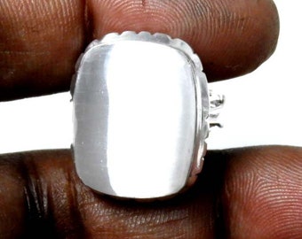 May include: A silver ring featuring a large, rectangular, white gemstone.