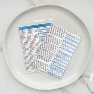 May include: Two laminated cards with blue and white text on a white background. The cards are titled "NIH Stroke Scale w/ Defaults" and "NIH Stroke Scale (NIHSS) - Mini-Mental (MMSE) or Clock Drawing Test (CDT)". The cards contain a list of stroke assessment criteria.