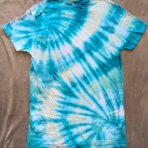 May include: A tie-dye t-shirt with a swirling pattern in shades of blue and white.