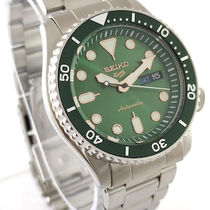 May include: A stainless steel Seiko automatic watch with a green dial and bezel. The watch features a date display and luminous hands and markers. The watch band is also stainless steel.