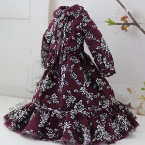 May include: A burgundy dress with a white floral pattern and a ruffled hem. The dress has a collared neckline and long sleeves.