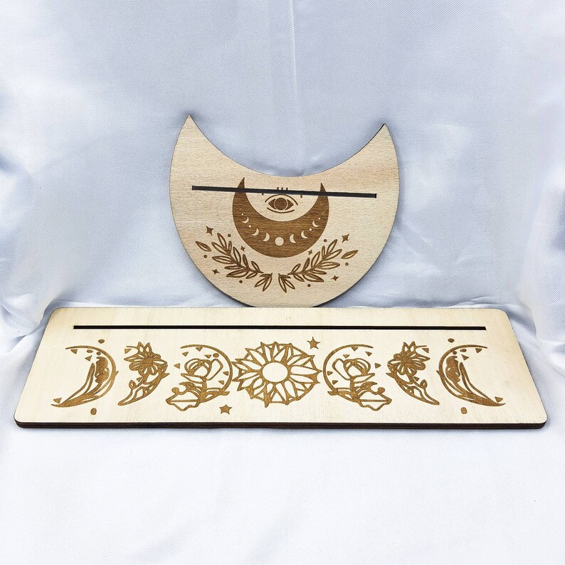 Op de afbeelding: Houten wierookhouder met maanfasen, met een halve maan ontwerp en een aparte standaard met zeven maanfasen, waaronder volle maan, halve maan en zon.